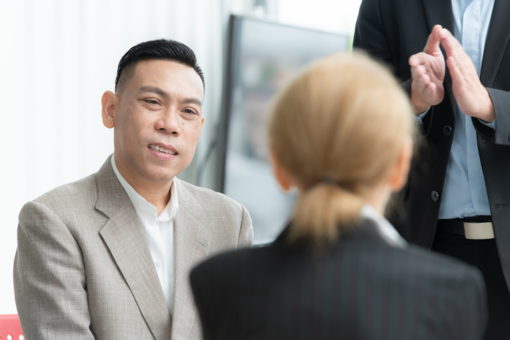 A man discusses his seo strategy for wealth managers with a woman at a conference table